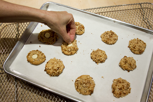 pressing white chocolate into warm cookies
