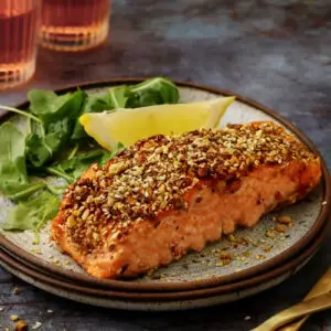 This dukkah-crusted salmon is the kind of weeknight dinner that tastes far more impressive than the effort it requires. A swipe of harissa-mayo helps the dukkah cling to the fish, creating a nutty, golden crust that stays crisp while the salmon stays tender. With dukkah in the freezer, this comes together in minutes.
