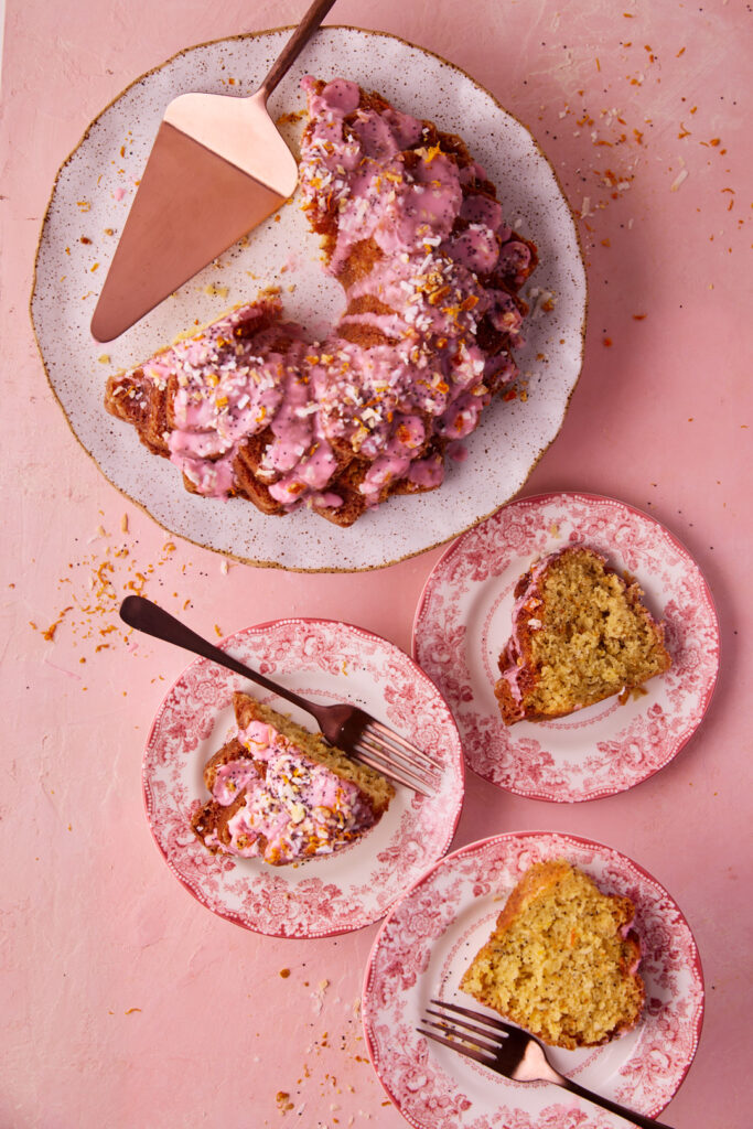 Overhead view of slices of Blood Orange Coconut Bundt Cake with pink glaze served on vintage floral plates.
